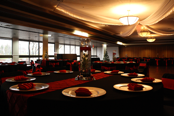 Salon decorated in red and black with chandelier and tables set for dinner