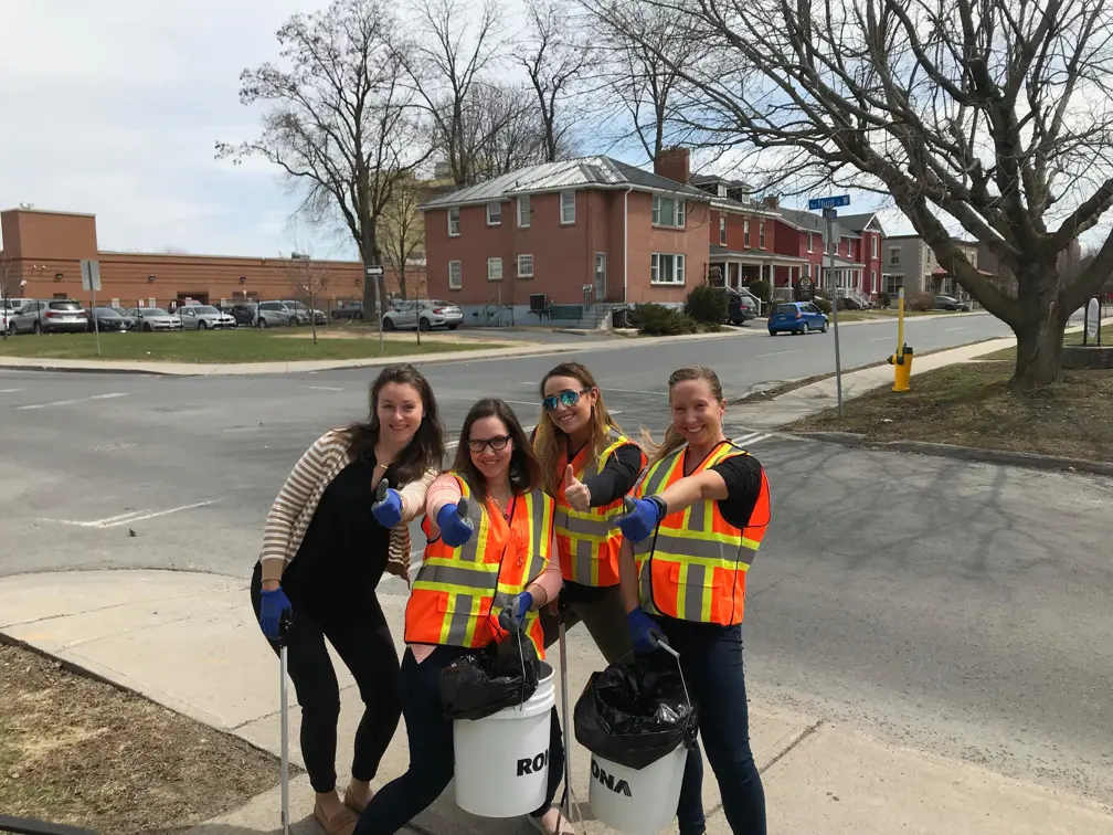 Four volunteer pose with thumbs up and litter picking equipment.